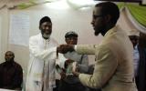 Abdi Yarow, Centre for Ihsan Education and Development, receives an Arabic DVD of 'The Imam and the Pastor' from Imam Muhammad Ashafa and Pastor James Wuye